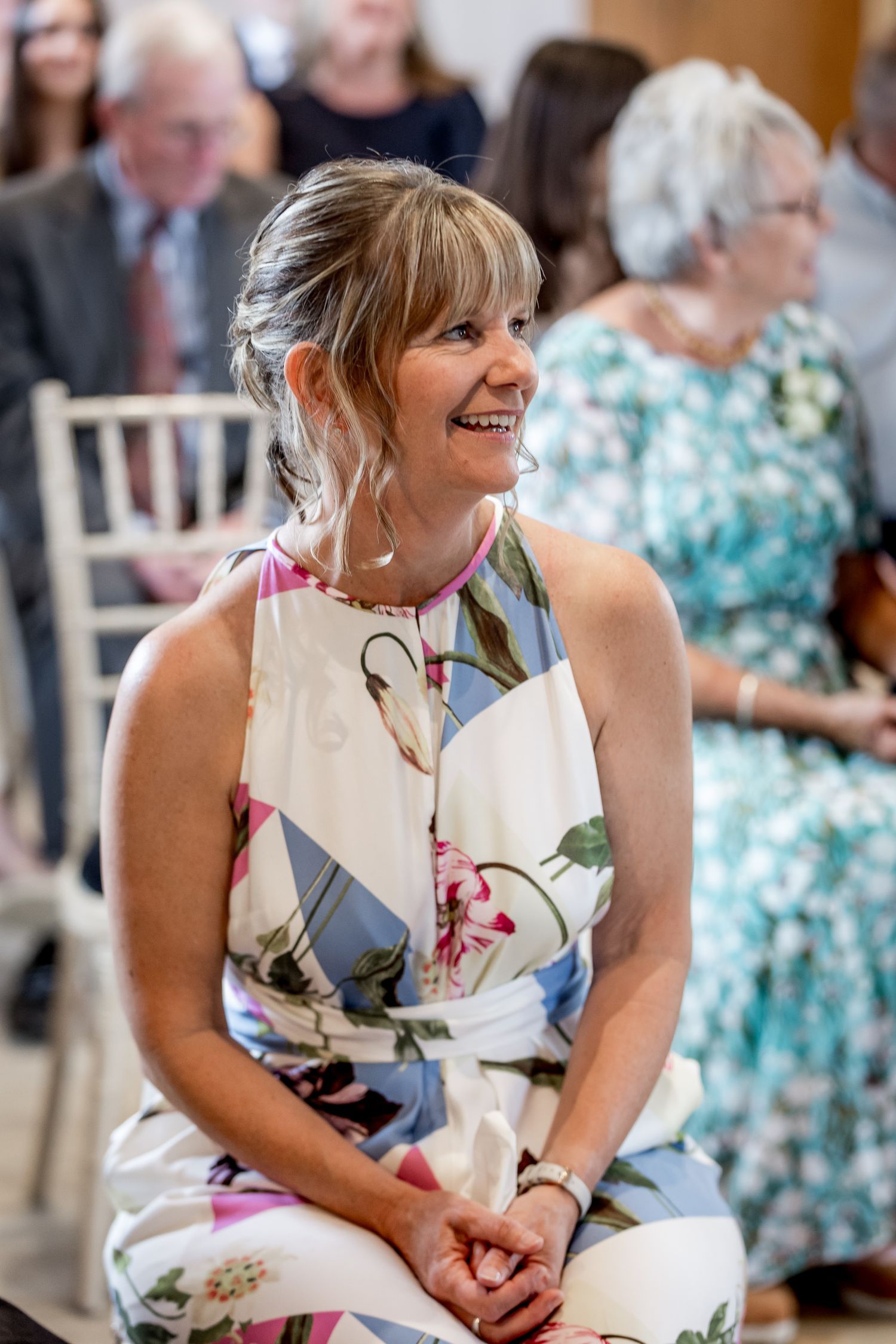 Wedding guests enjoying the celebration in floral dresses at an indoor venue.