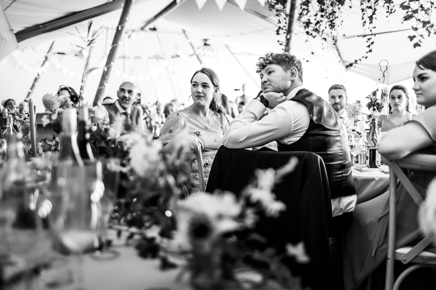 Black and white wedding reception scene with decorative bunting and natural lighting.