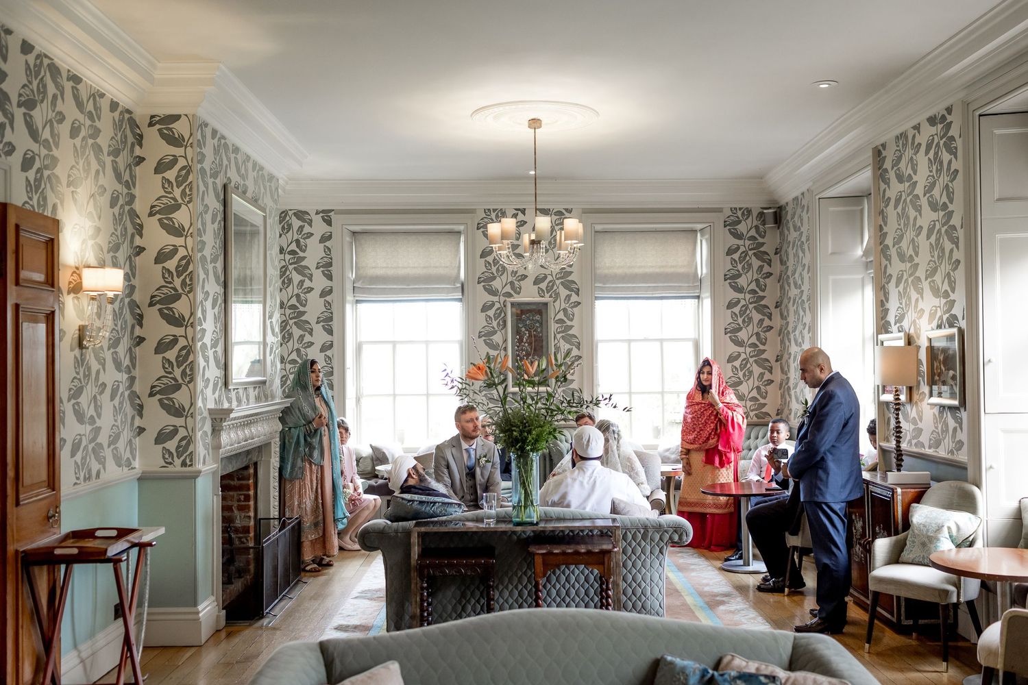Interior of an elegant room with floral wallpaper and crystal chandelier.