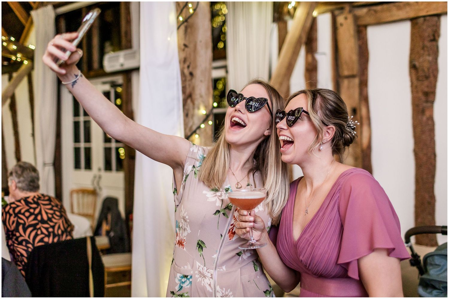 Wedding guests take a selfie at a reception at Hampshire's Clock Barn wedding venue