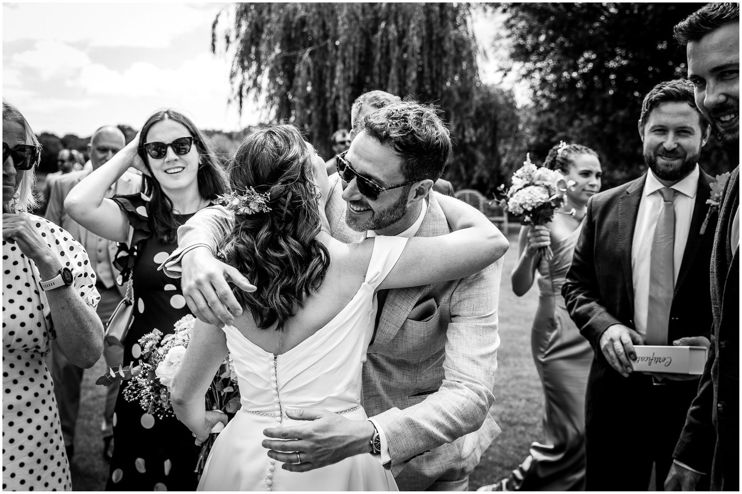 Documentary wedding photography as a guest congratulates the bride on her marriage at Sopley Mill