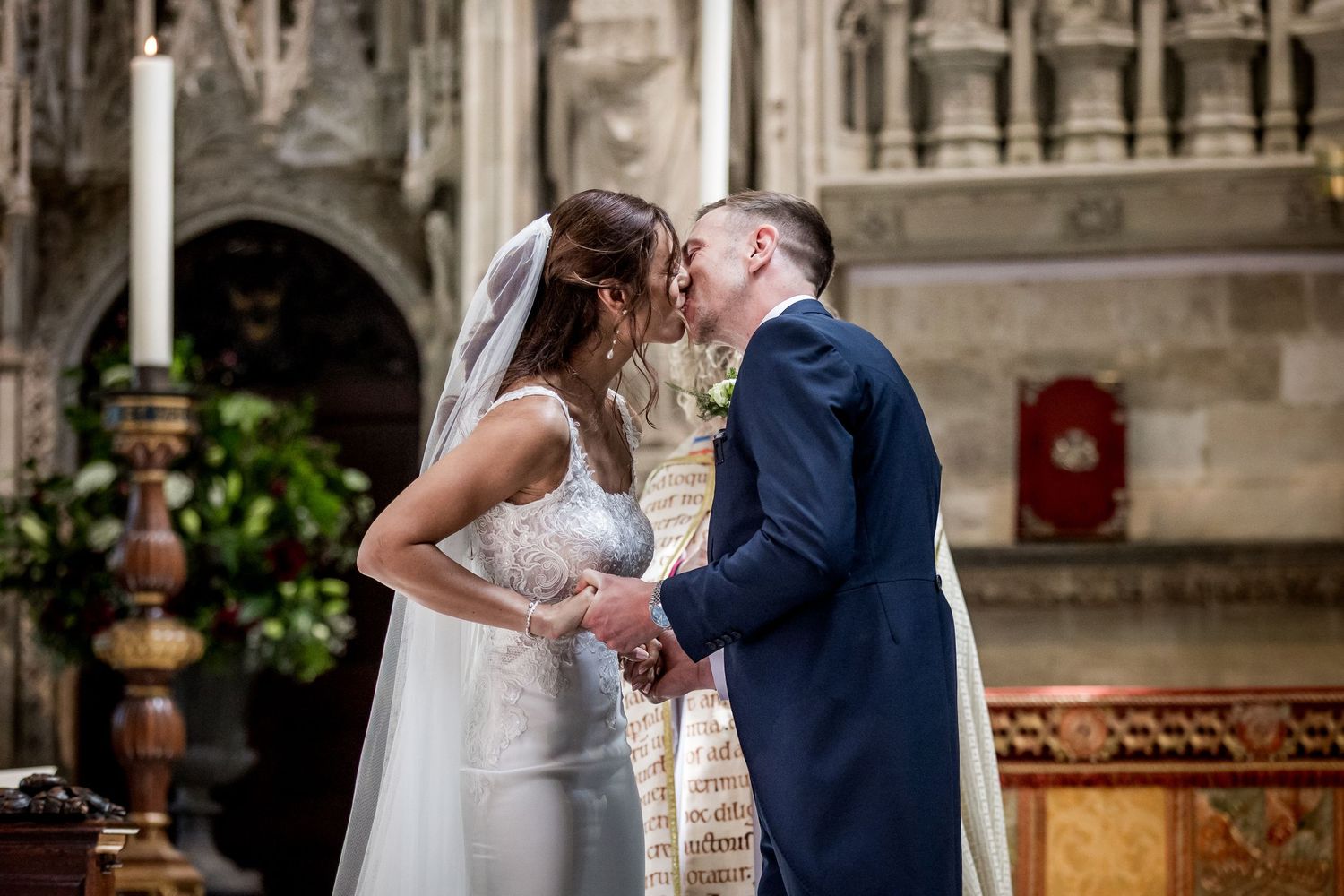 Elegant wedding ceremony taking place in historic cathedral with gothic architecture.