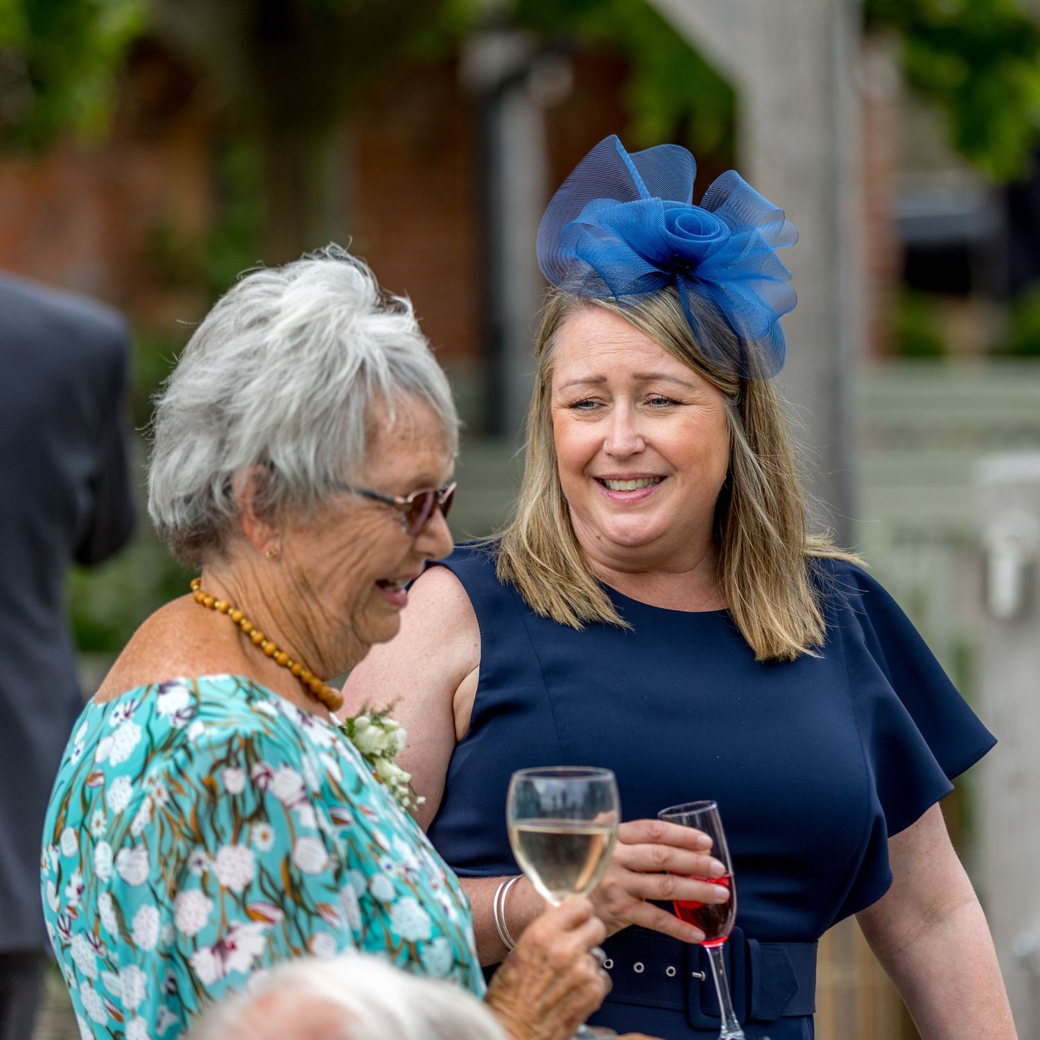 Wedding guests chatting and enjoying drinks at an outdoor summer reception.