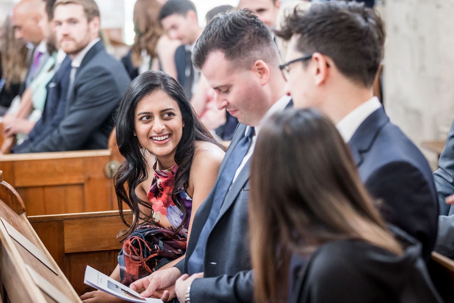 Wedding guests seated in church pews during the ceremony.