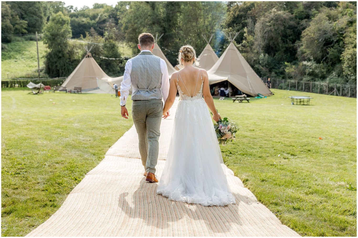 Wedding celebration with tipi tent setup in a scenic countryside location.