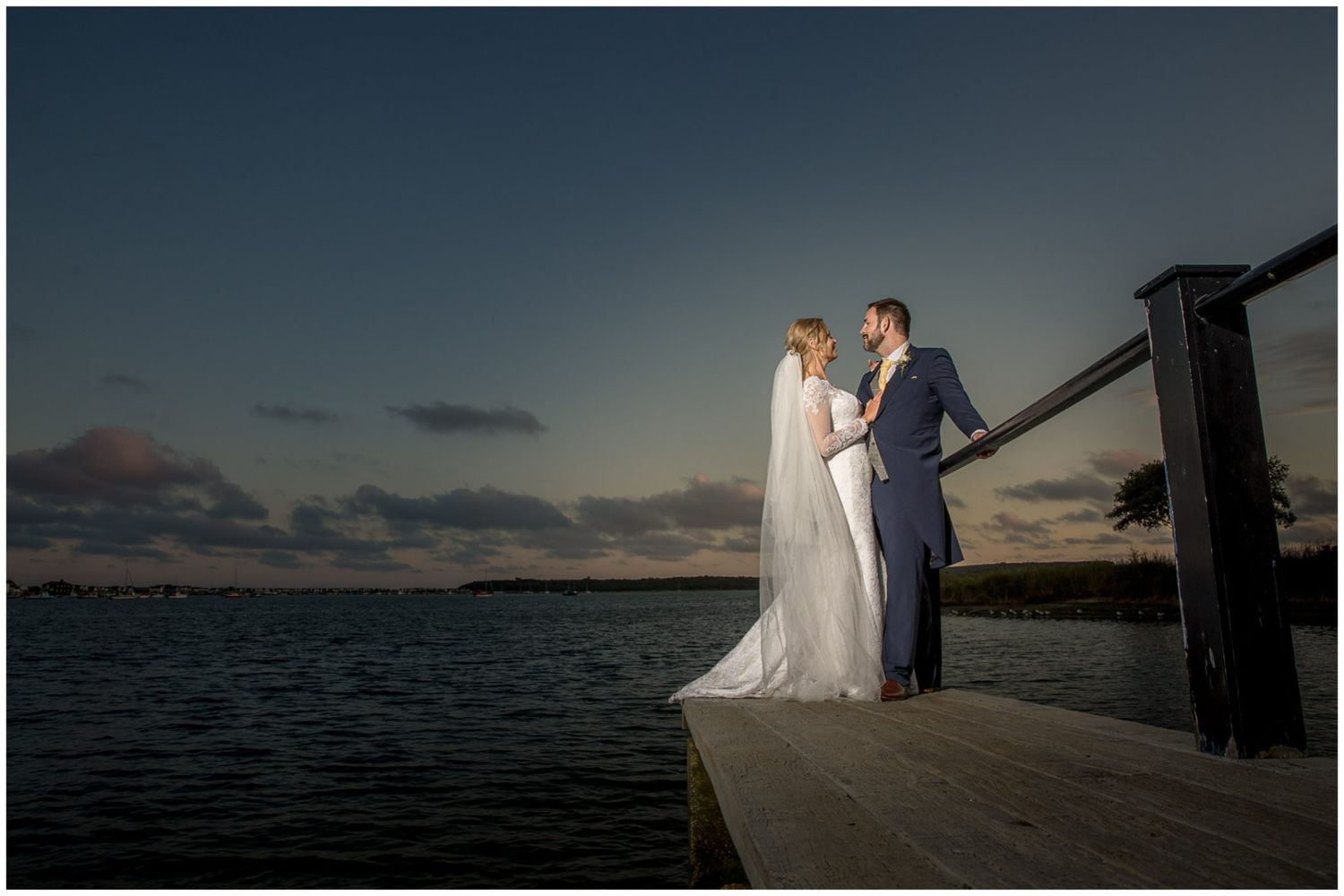 Romantic wedding couple poses at sunset on a pier overlooking the ocean in multiple scenic shots.