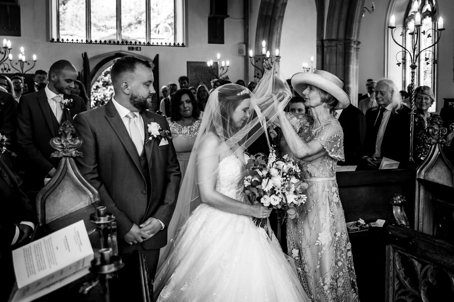 Wedding ceremony in a historic church with ornate stained glass windows and traditional architecture.
