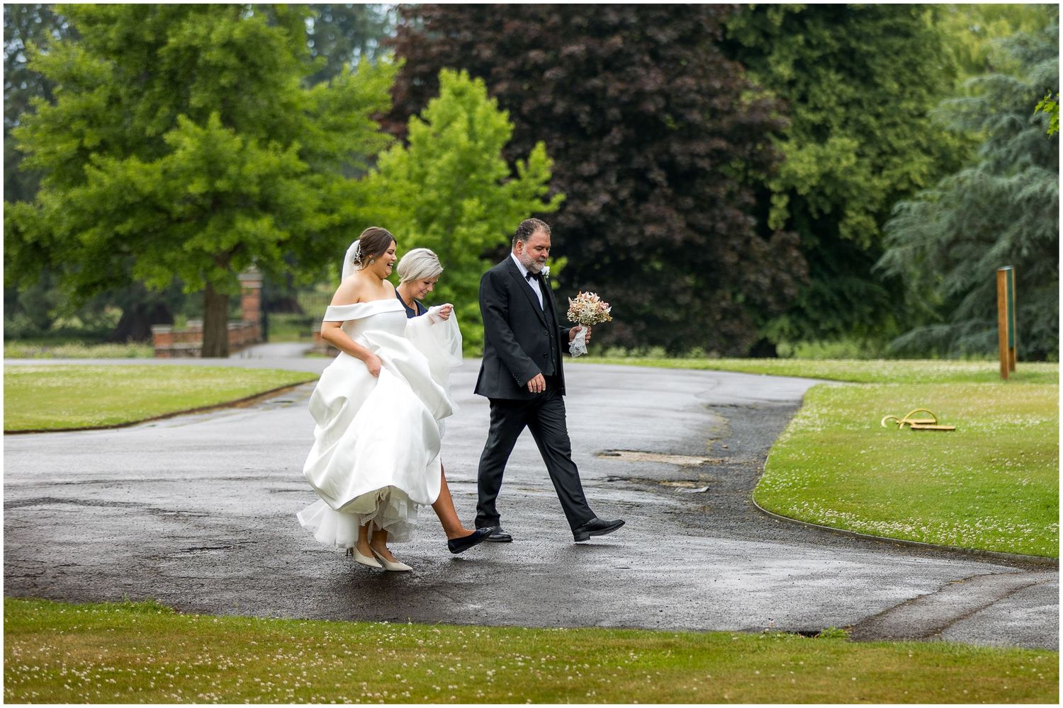 The bride and her father walk towards the wedding chapel at the Elvetham for the ceremony