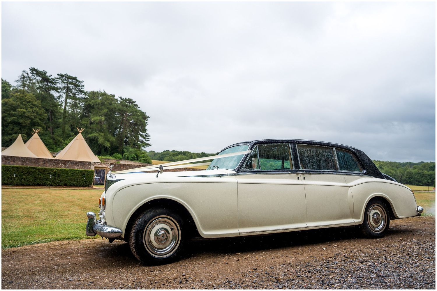 A Rolls Royce wedding car arrives outside the walled garden at the Holywell Estate