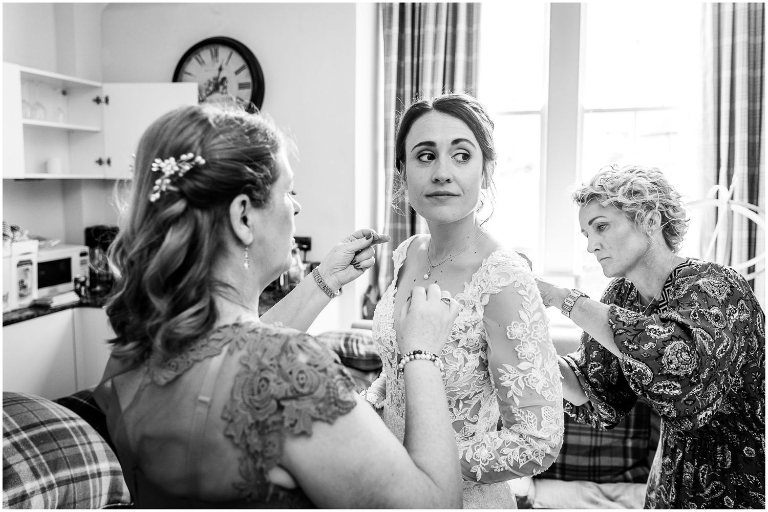 Black and white image of wedding preparations with focus on details and expressions.