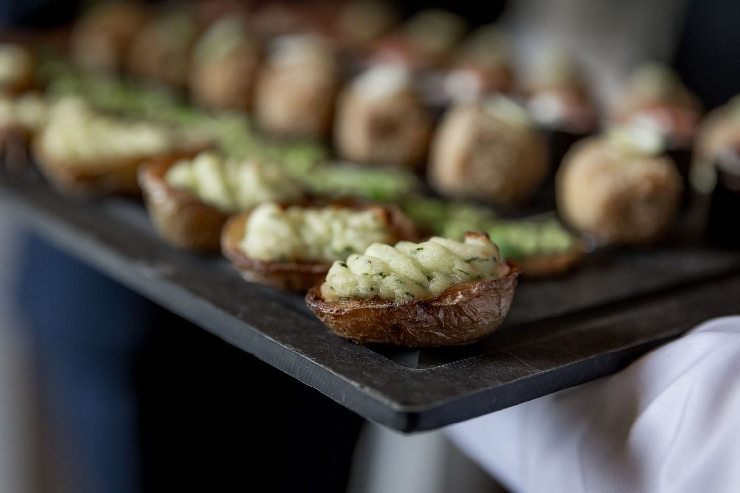 Close-up of gourmet appetizers arranged on dark serving platters.