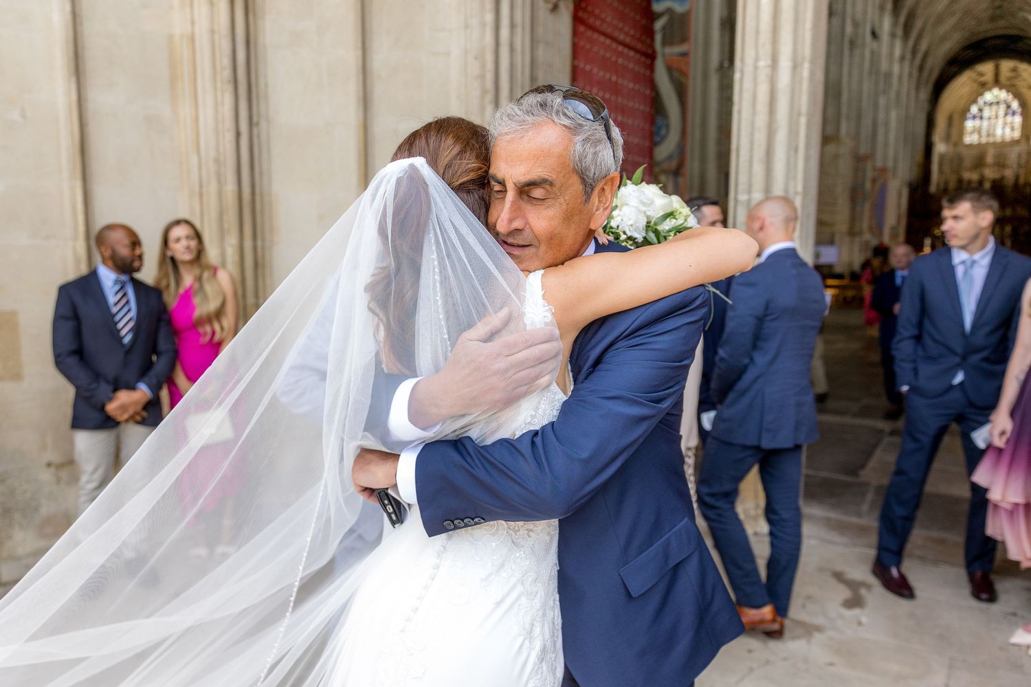 Wedding celebration moments captured in a cathedral's stone archway entrance.