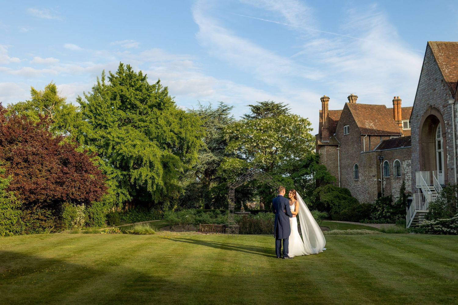 Panoramic view of wedding venue with historic buildings and manicured lawns.