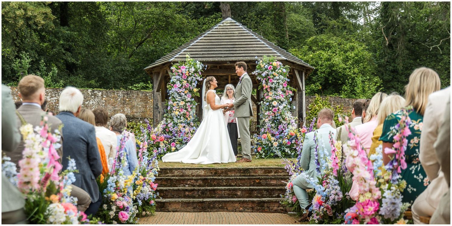 Wedding photograph from the end of the aisle with impressive floral decorations at Hampshire's Holywell Estate