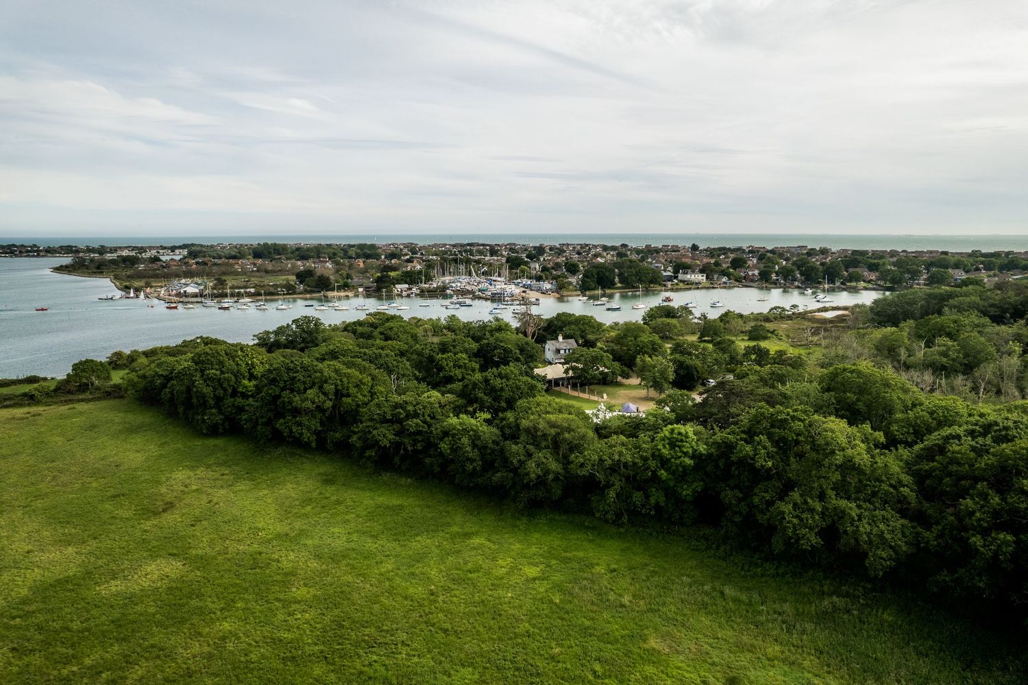 Aerial panorama of coastal town surrounded by green landscape and waterways.