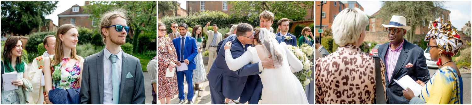 Wedding party and guests socializing on church grounds during outdoor reception.