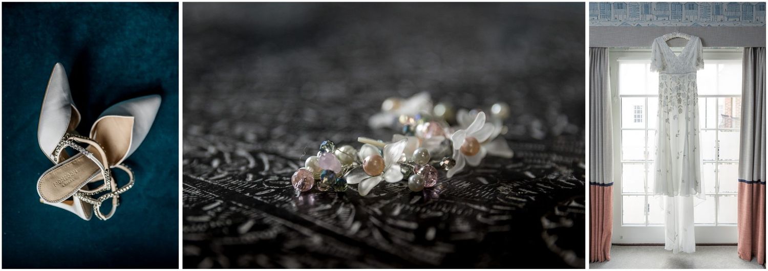 Wedding details featuring elegant rings, delicate pearls, and a flowing white dress hanging by a window.