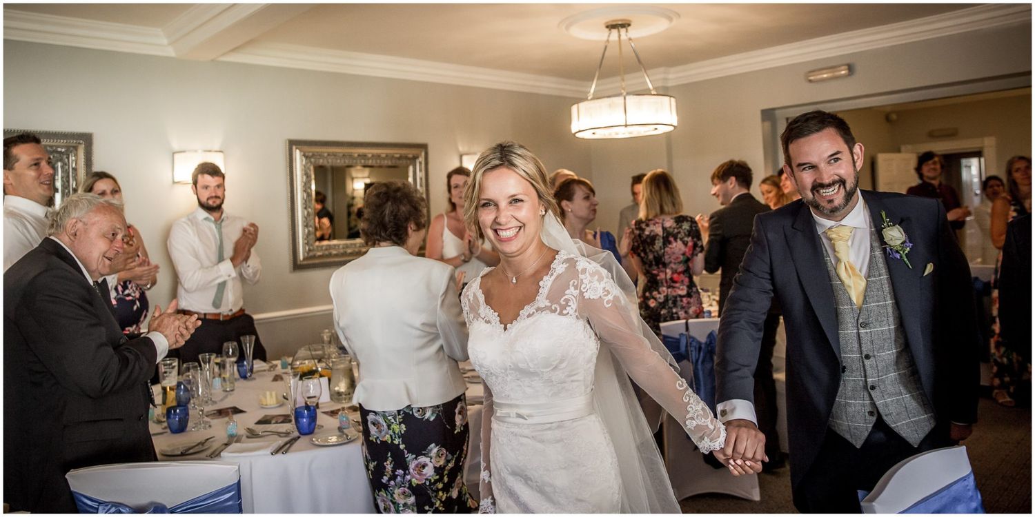 Wedding reception guests celebrate and dance together on the dance floor during an indoor evening celebration.