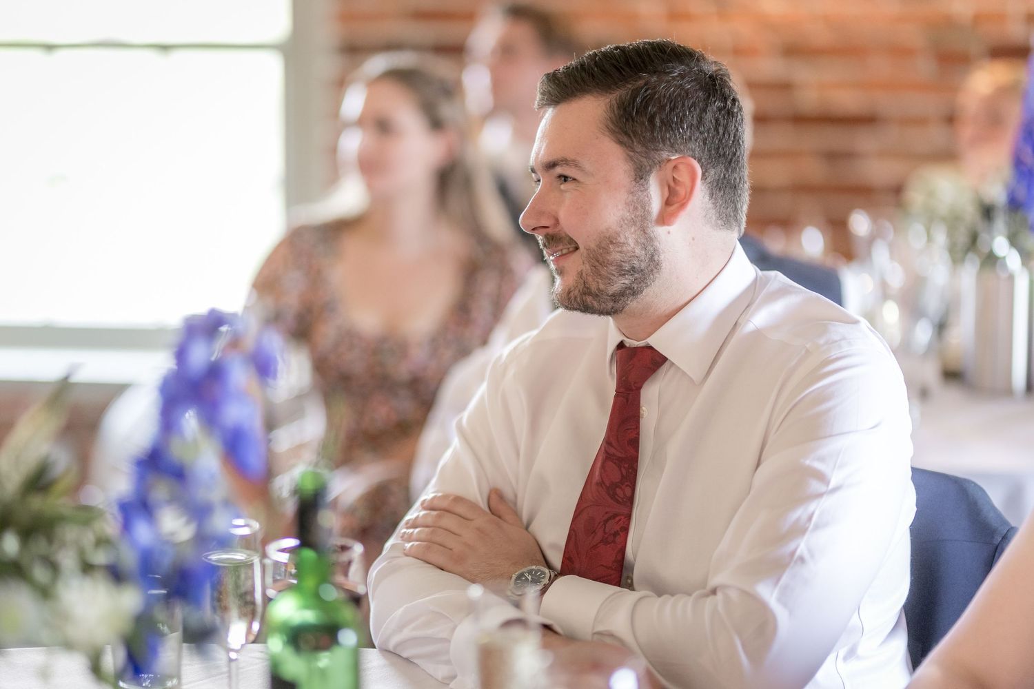 Guests in formal attire seated at tables during a wedding reception.