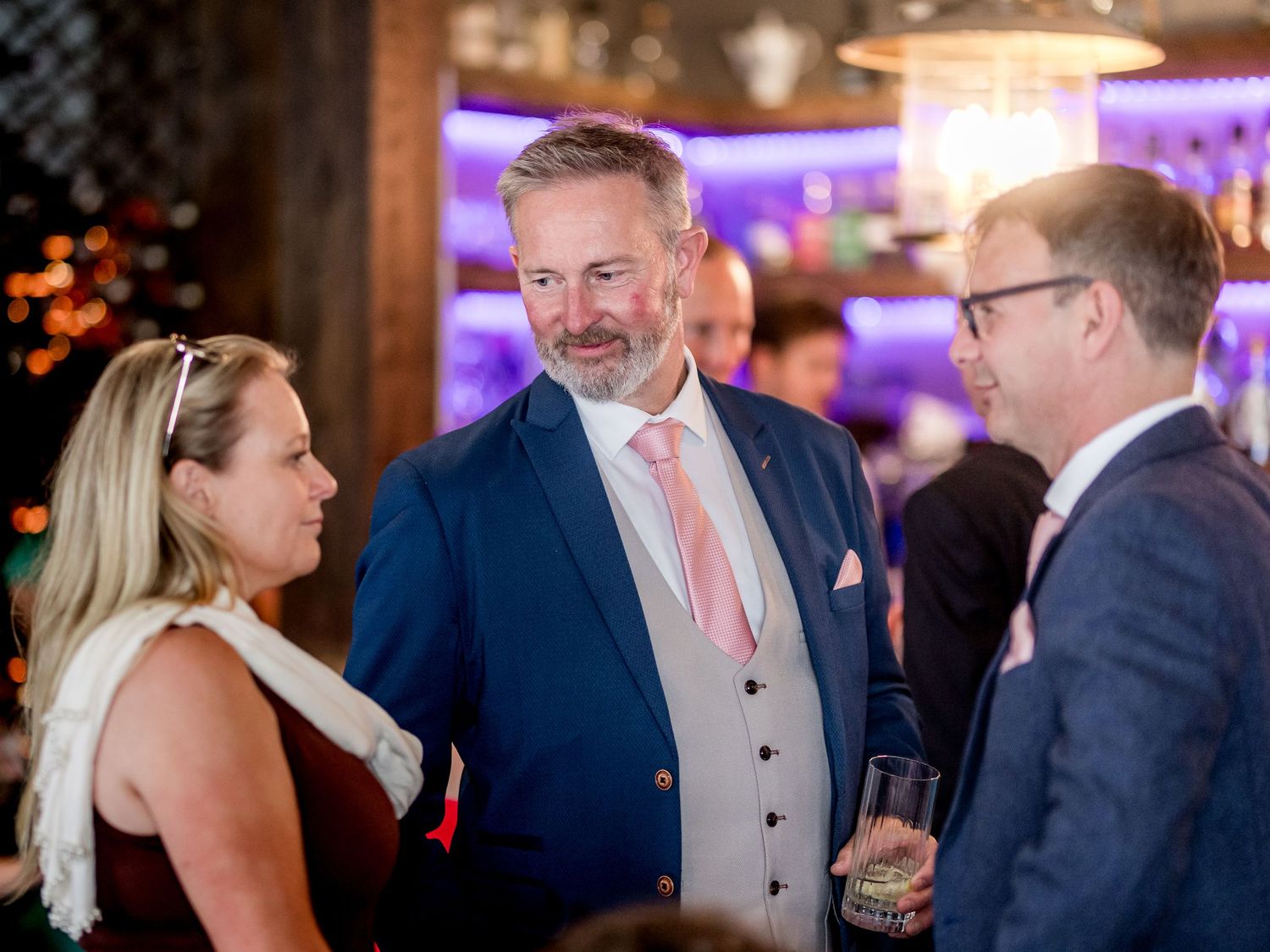 Evening celebration with guests mingling and socializing at an indoor venue.