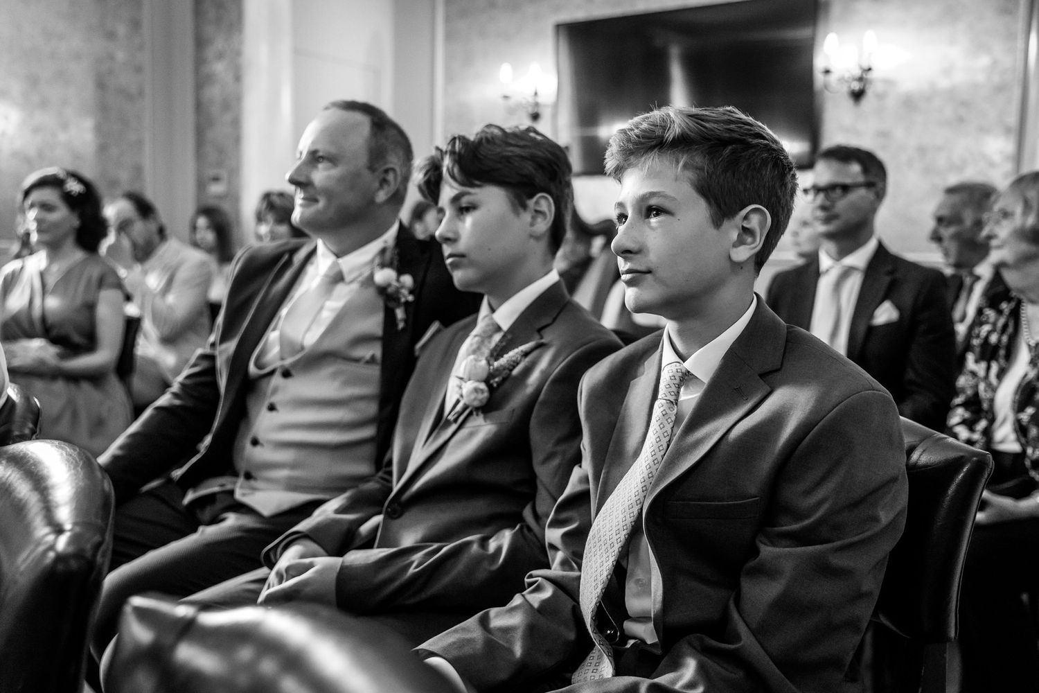 Black and white photo of wedding guests seated in rows during ceremony.