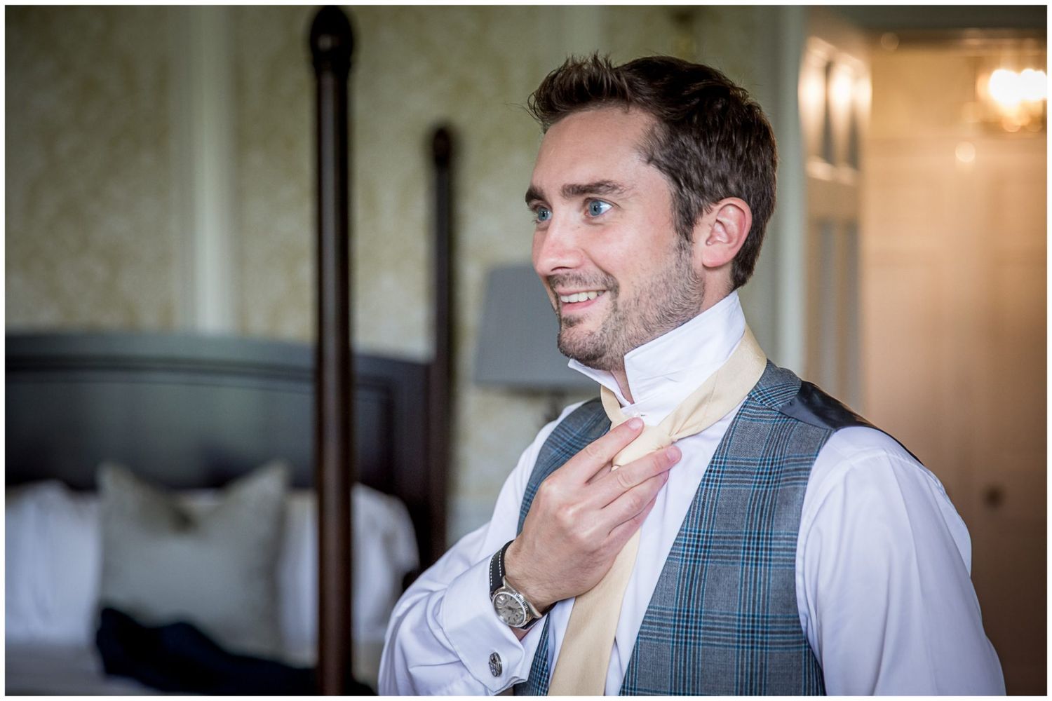 Groomsmen in gray vests and white shirts share laughs during wedding preparations.