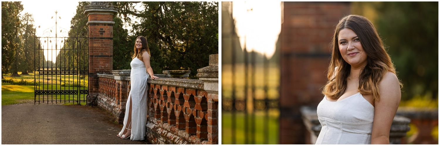 A woman in a white gown poses at sunset near a brick pillar and iron gate in a garden setting.