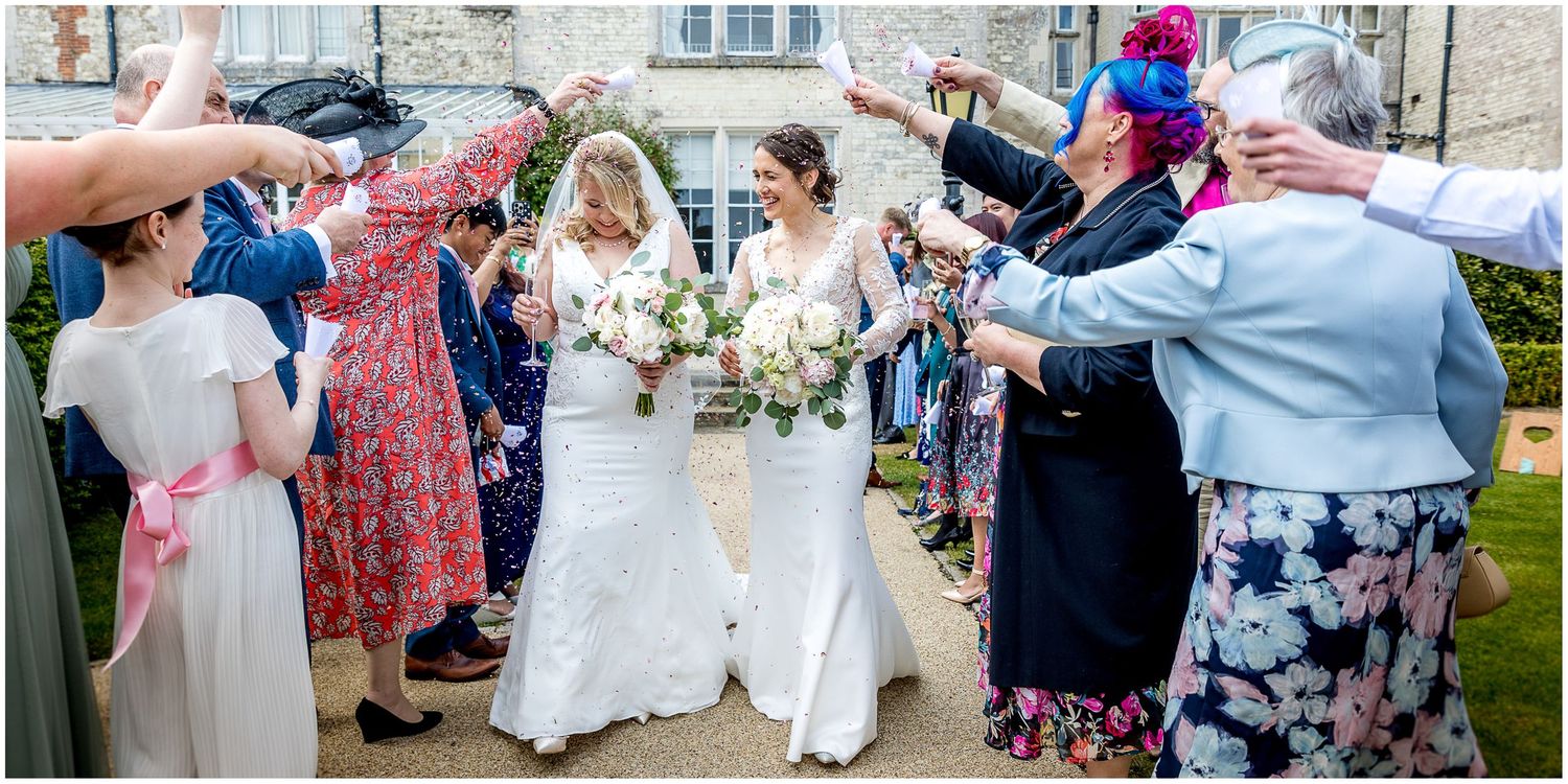 Wedding guests in colorful attire celebrate during an outdoor garden reception.