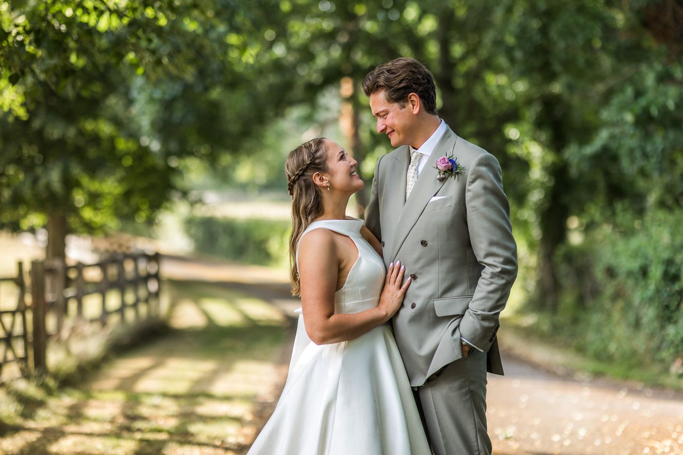 Romantic outdoor wedding portraits in a sunlit garden path.