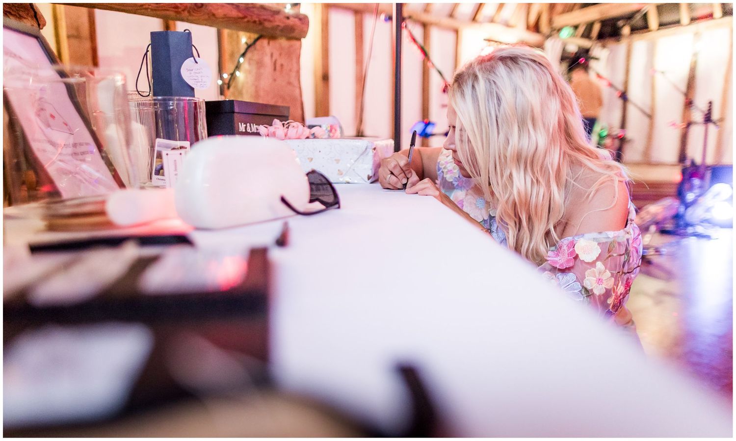 A wedding guest signs the guest book in the evening reception