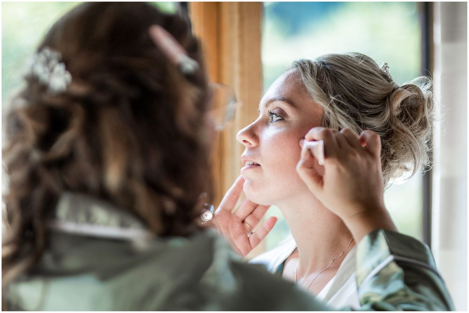Wedding preparation scene by a bright window with natural light streaming in.