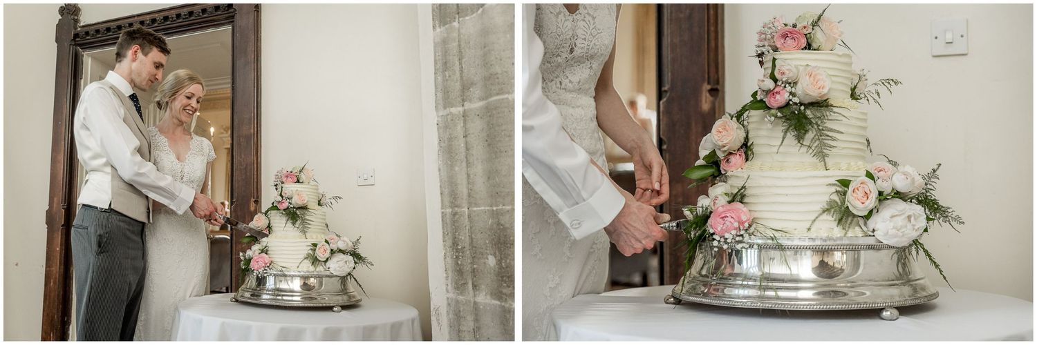 Wedding cake being cut on a silver stand with delicate floral decorations.