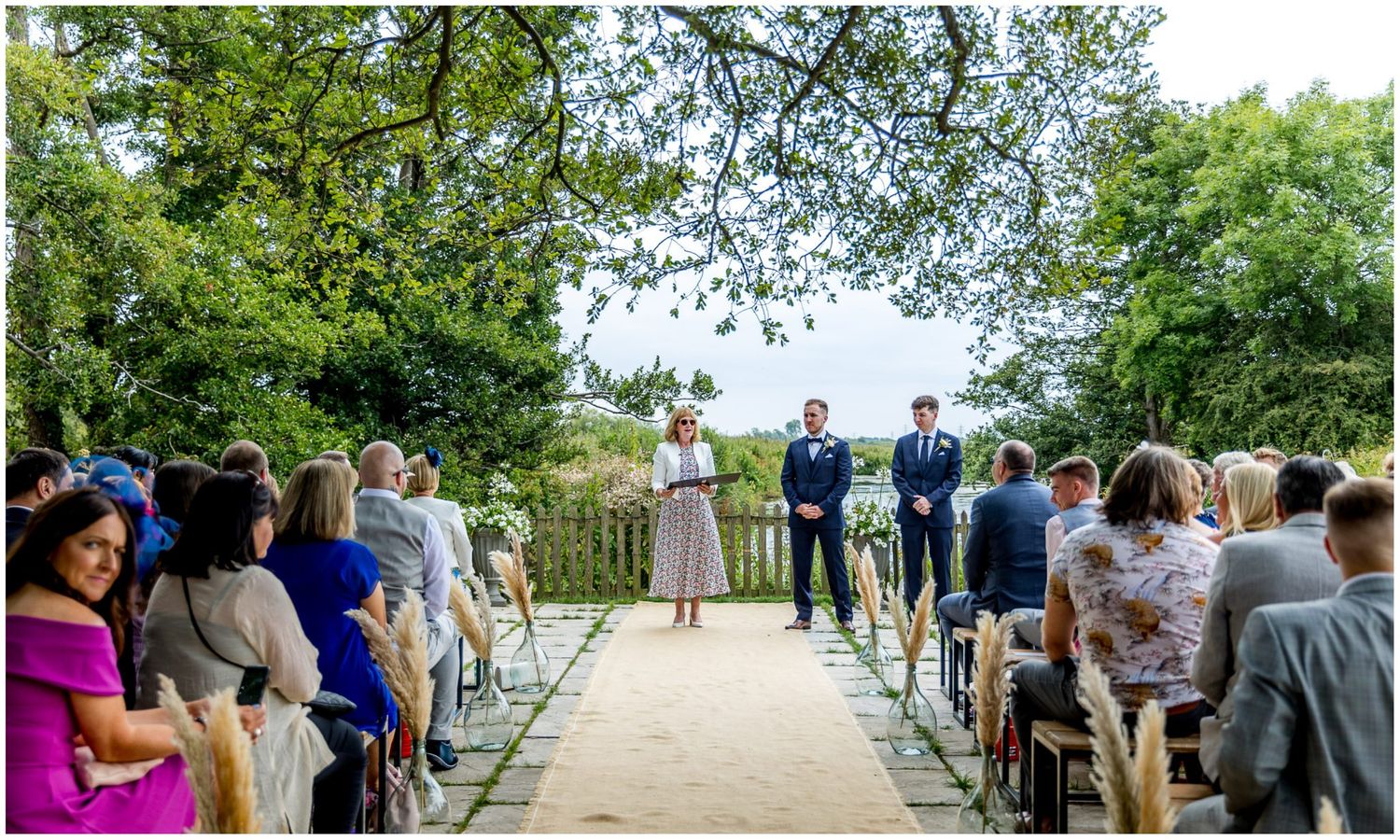 Beautiful outdoor wedding ceremony setup with white chairs and natural garden backdrop.