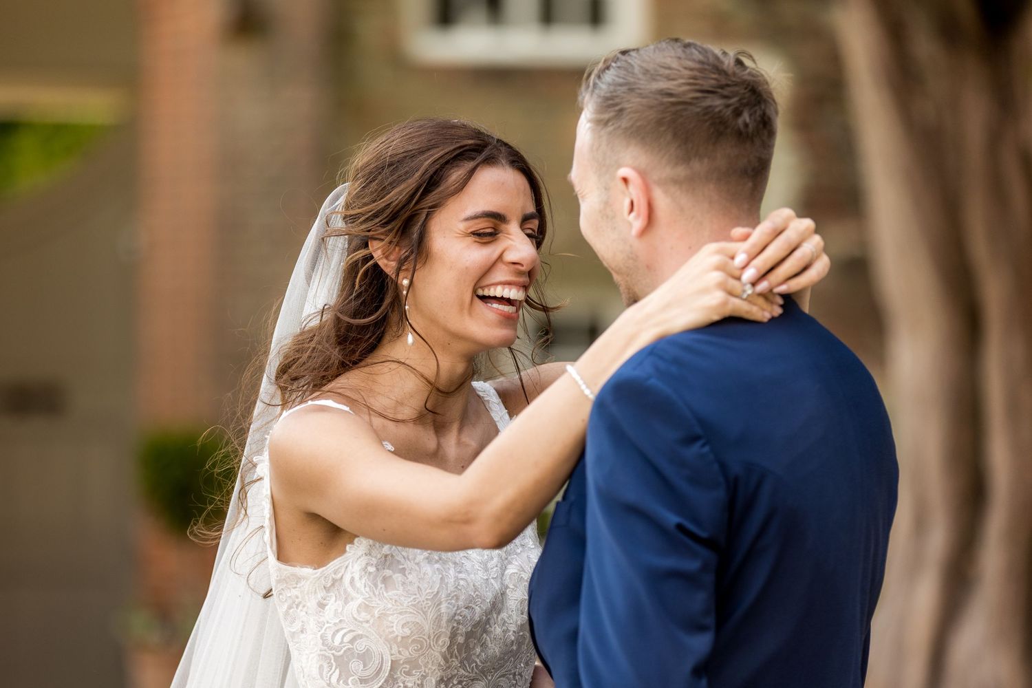Joyful wedding couple sharing intimate moments in outdoor garden setting.