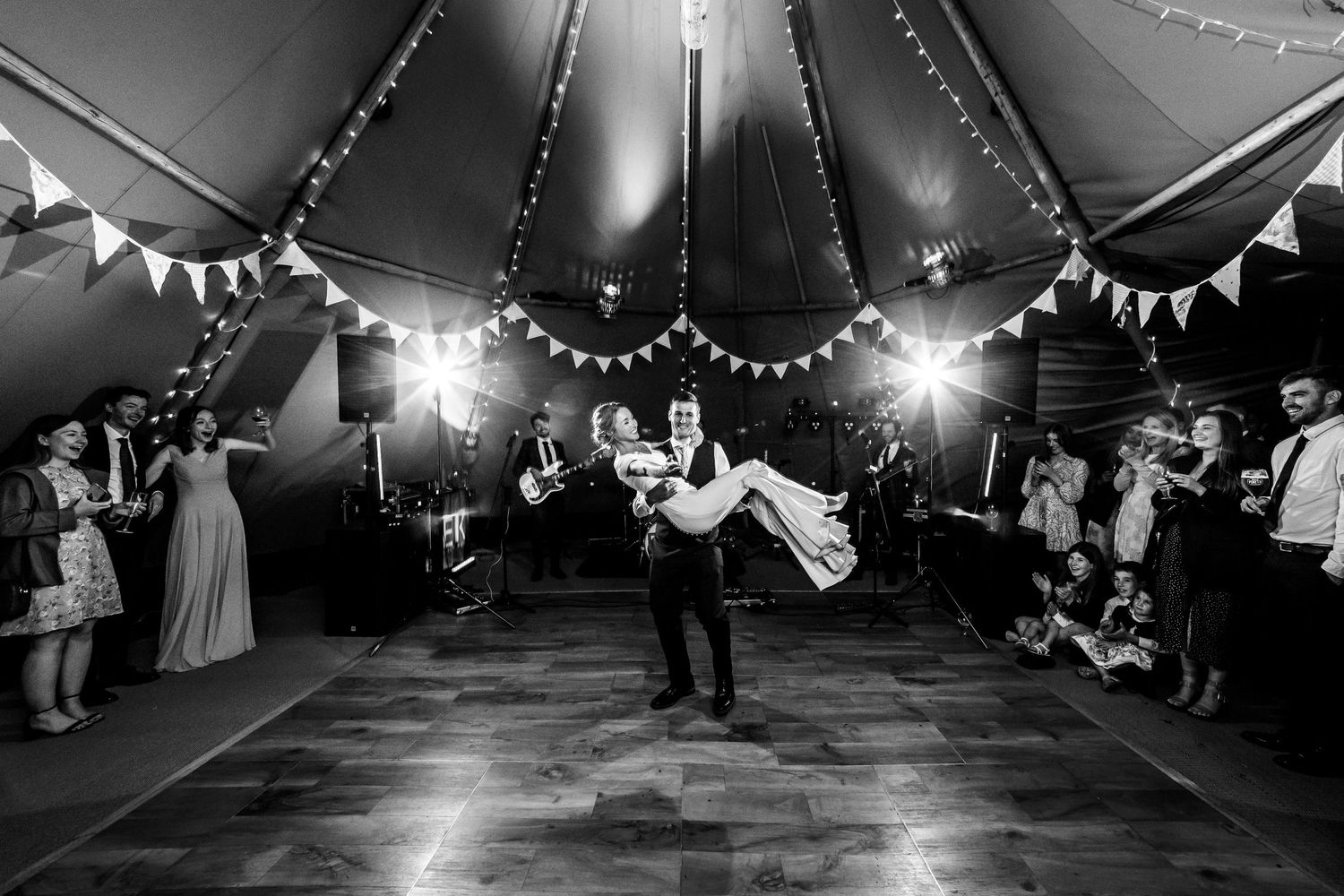 Black and white first dance wedding photograph in the reception marquee at Hampshire's Holywell Estate
