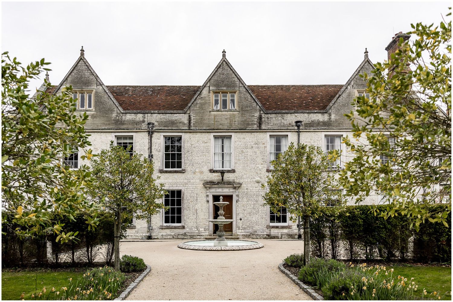 Elegant white stone manor house with traditional architecture and manicured grounds.