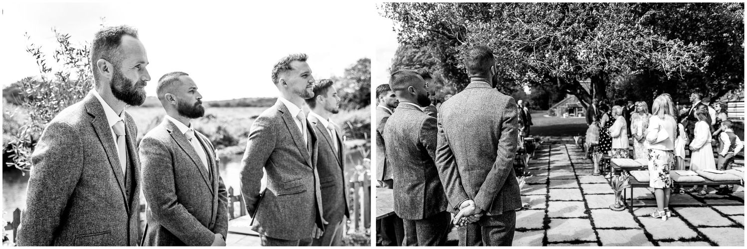 Wedding guests gather outdoors for a ceremony under trees in black and white.