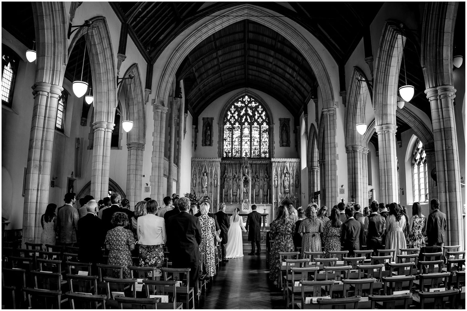 Black and white panoramic view of a cathedral's dramatic interior architecture.