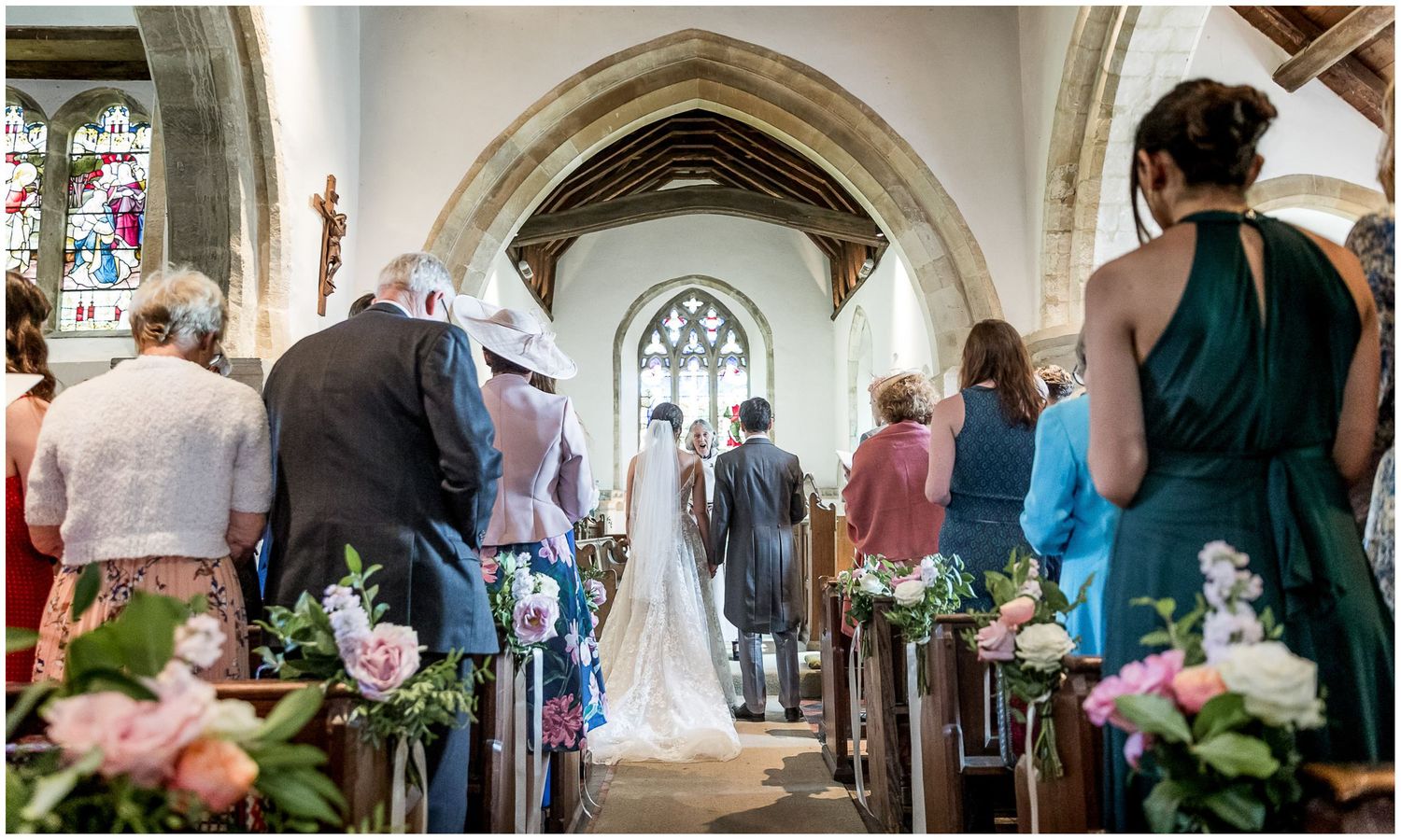 Church wedding venue with gothic arches and floral decorations along the aisle.