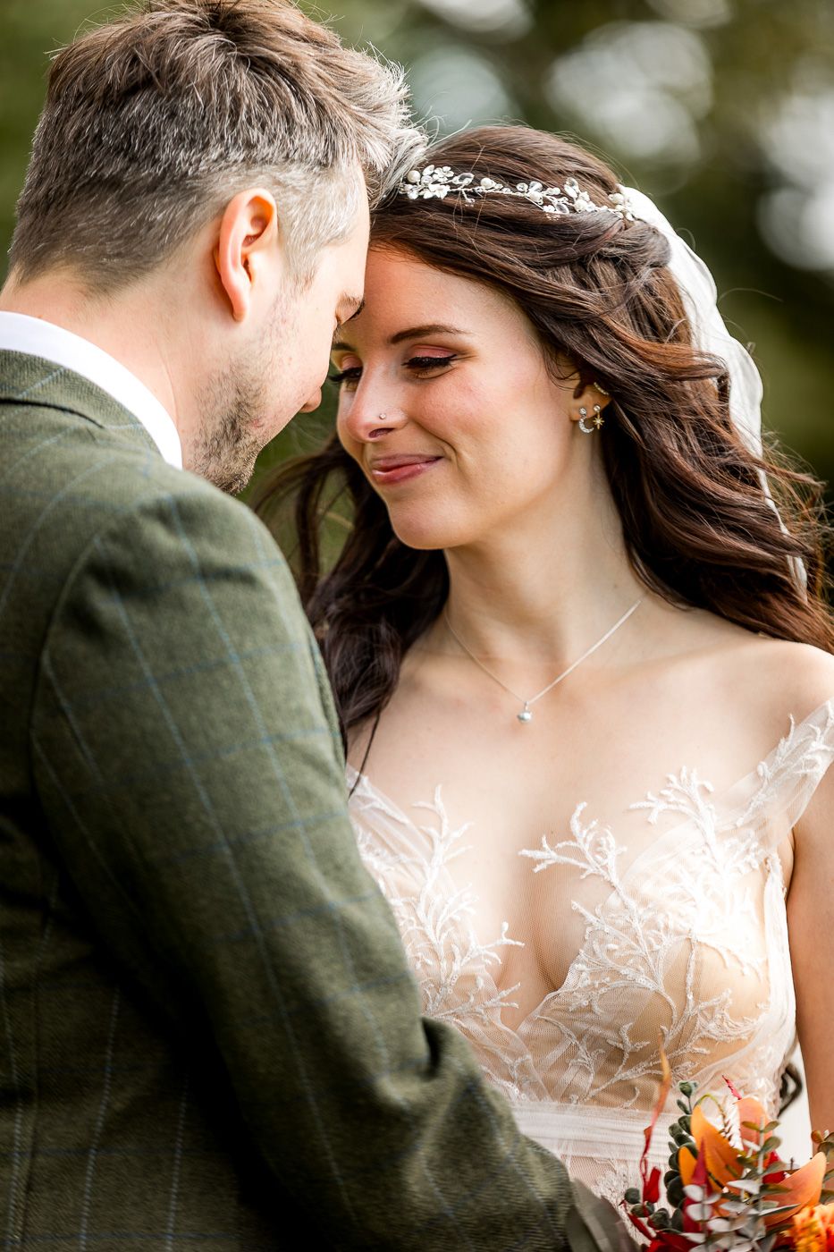 Intimate wedding portrait captures romantic moment between couple in outdoor setting.