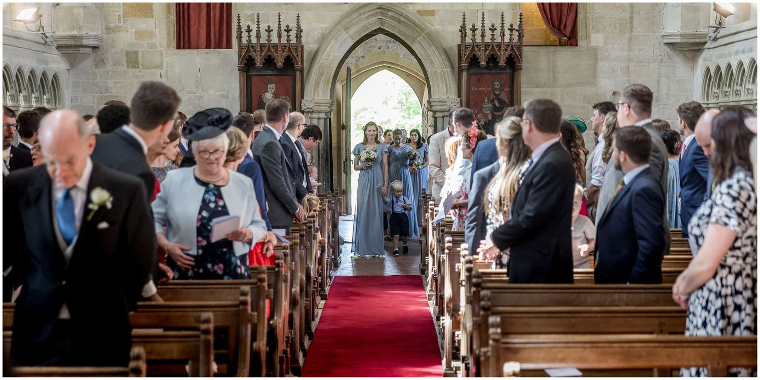 Traditional church interior with red carpet aisle and wooden pews.
