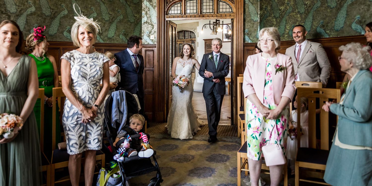 Wedding celebration in an ornate room with vintage wallpaper and wooden details.