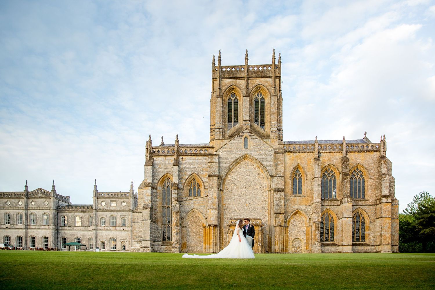 A panoramic view of Milton Abbey, a historic Gothic church and school buildings in Dorset, England.