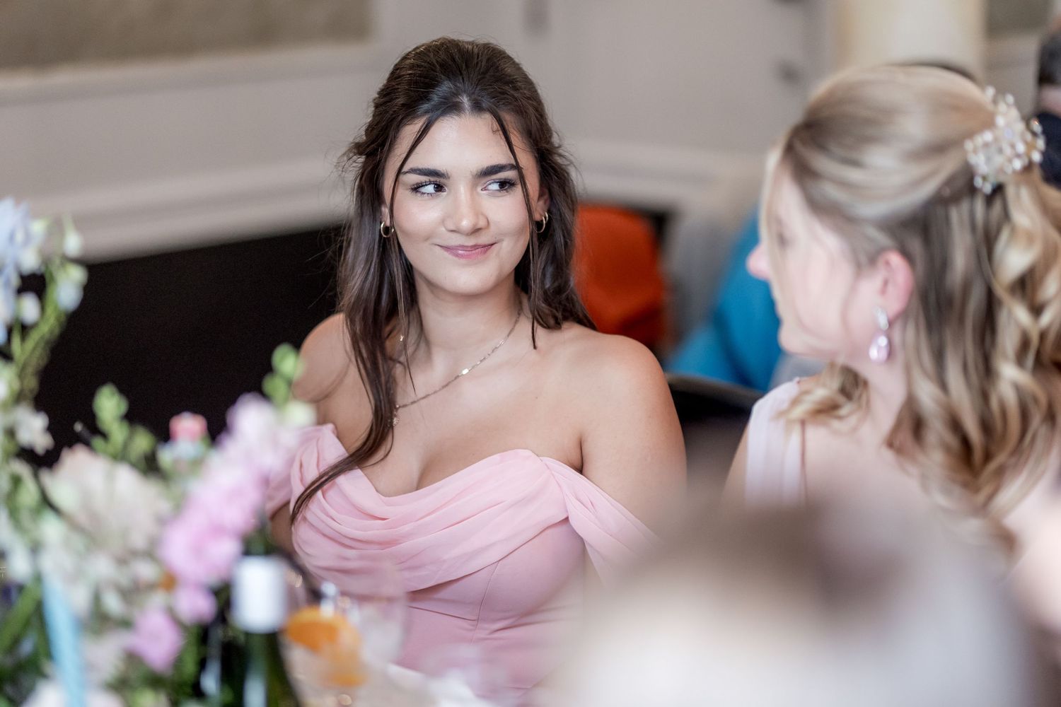 Guests in formal attire at an elegant celebration with soft lighting.