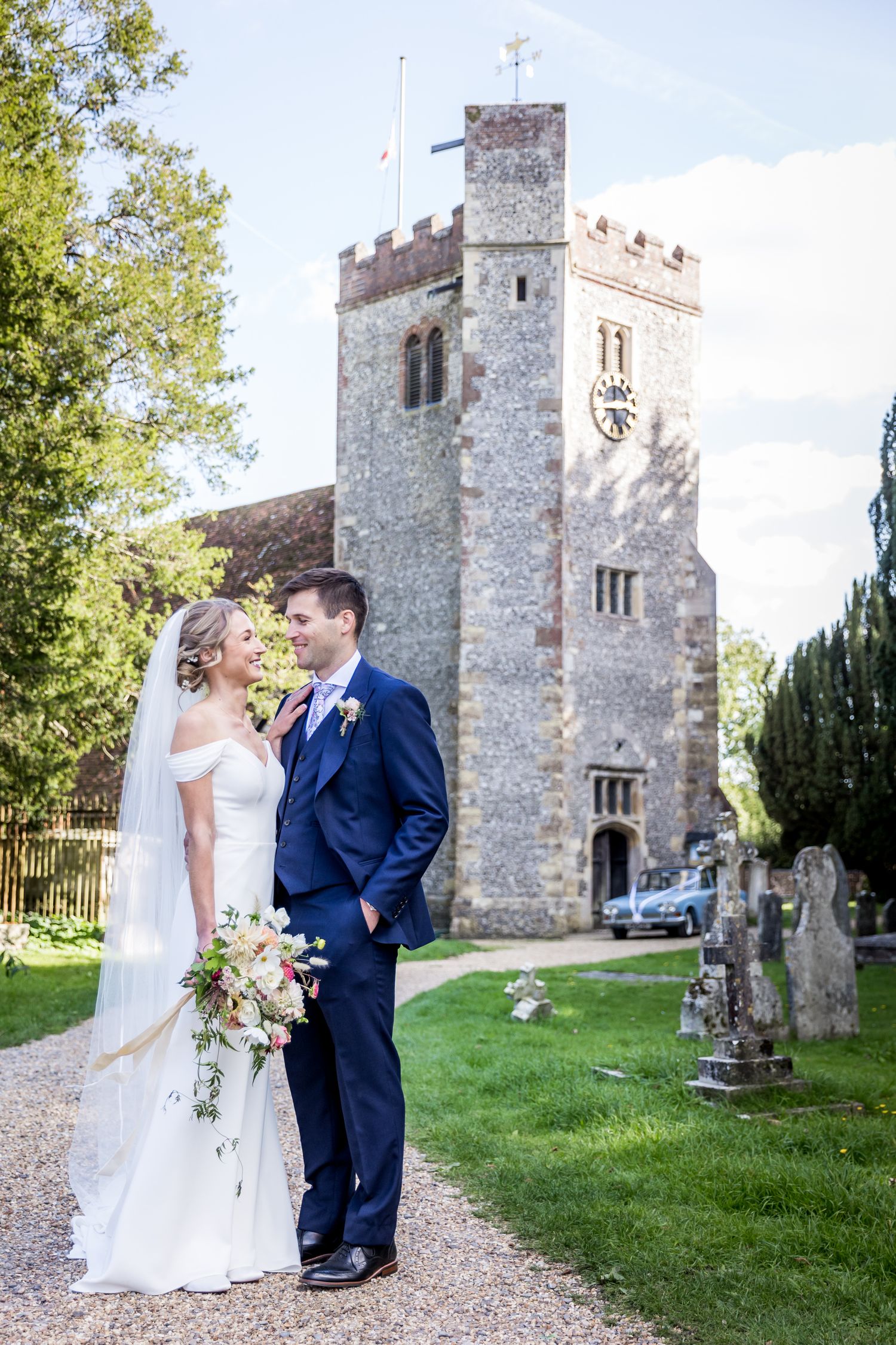 A romantic wedding photoshoot outside a historic stone church with beautiful grounds.