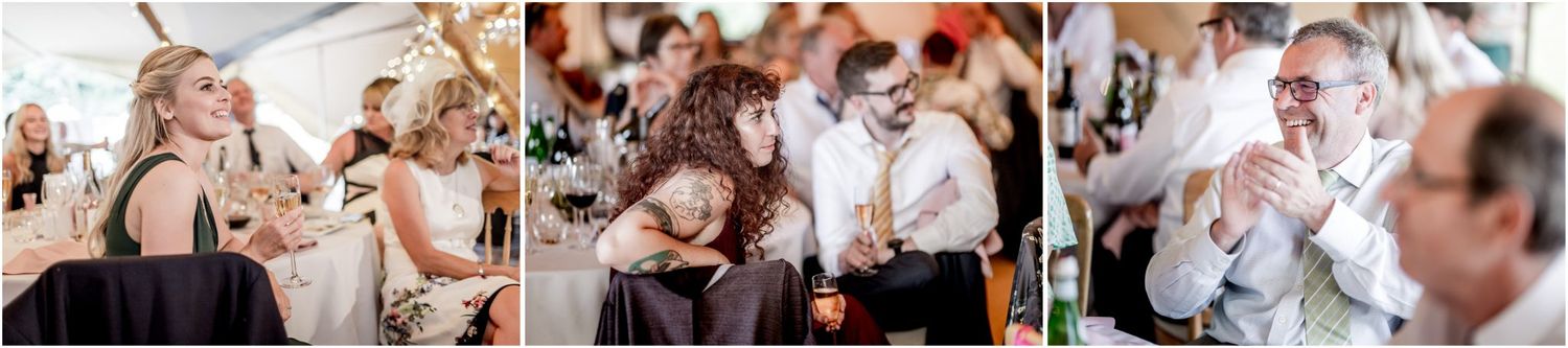 Guests celebrate at a lively wedding reception under a decorated tent.