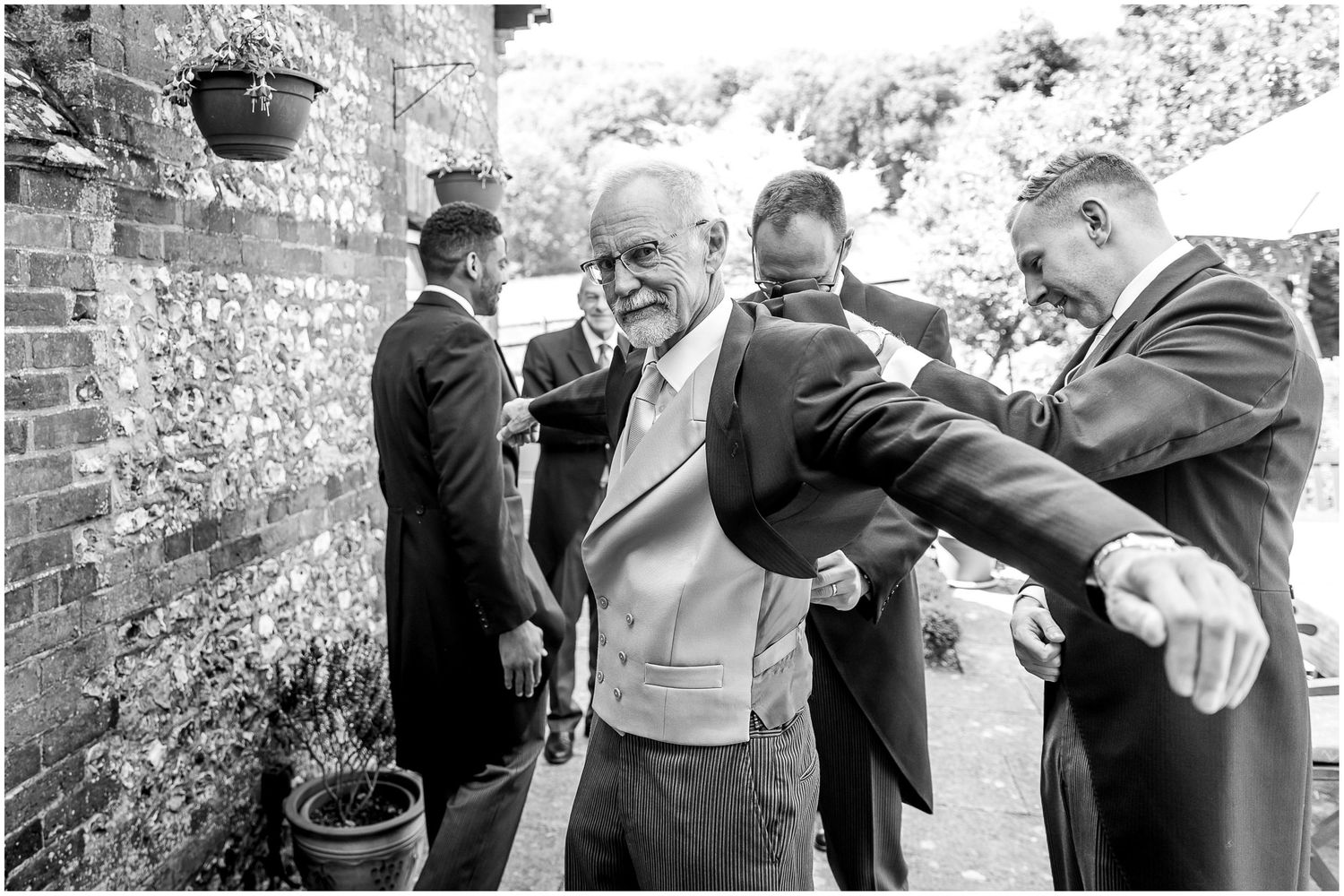 Candid black and white photos of guests socializing at an outdoor stone venue.