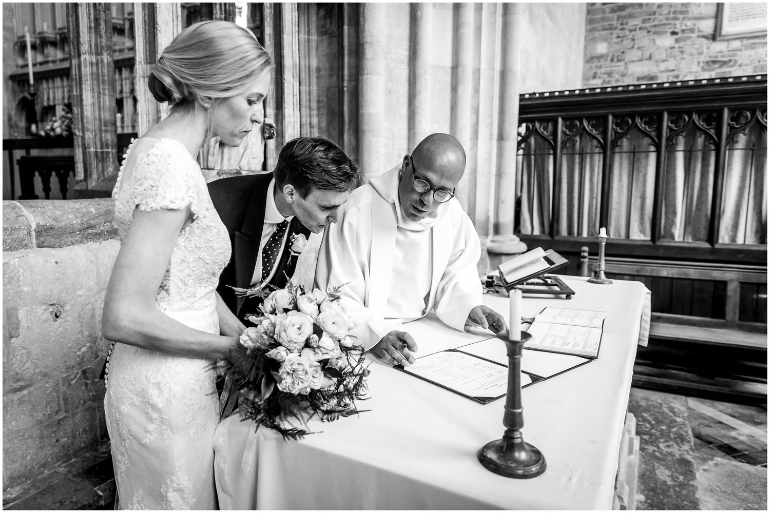 Wedding guests signing the registry inside a historic stone church.