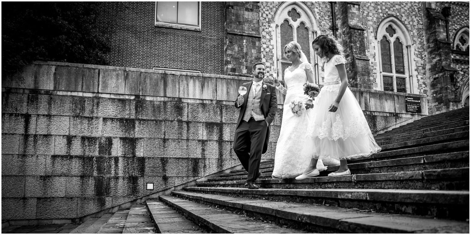 A bride and groom pose for romantic black and white wedding photos on stone steps and archways.