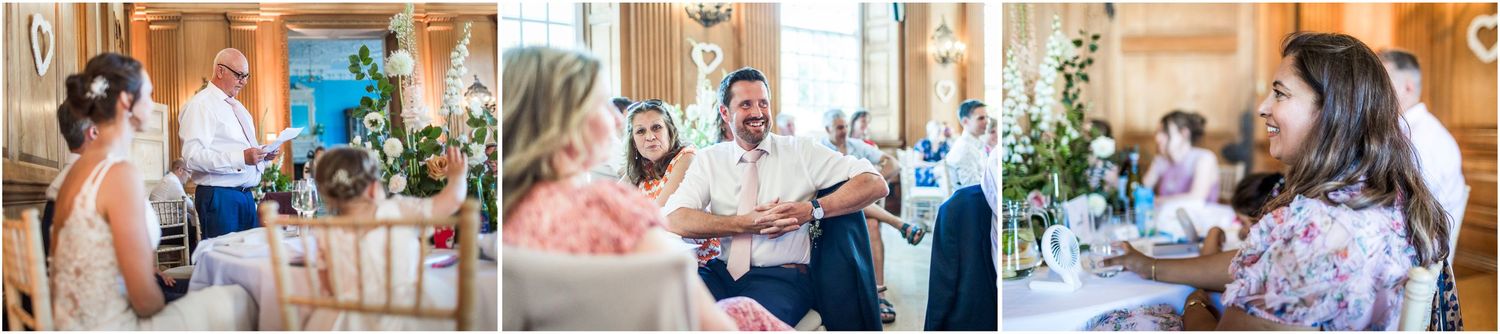 Guests laughing and conversing at elegant wedding reception with floral decorations and natural light.